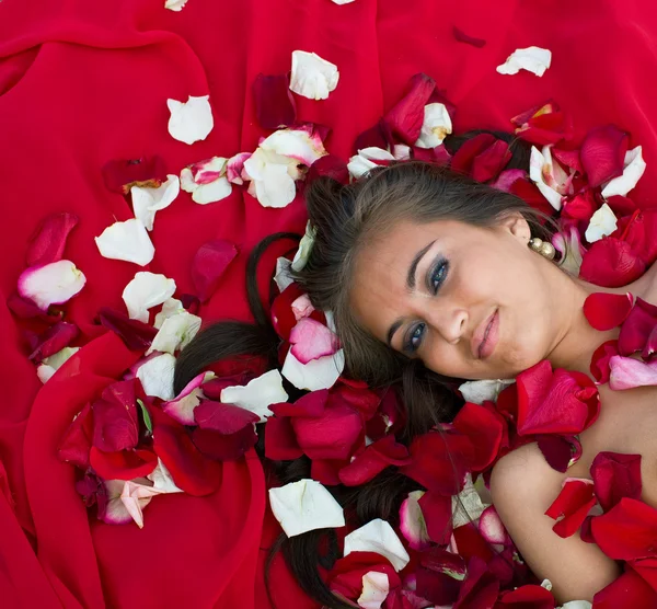 Dziewczyna w płatek róży — Zdjęcie stockowe