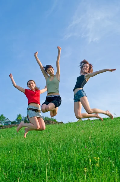 Girls jump on the meadow Stock Photo