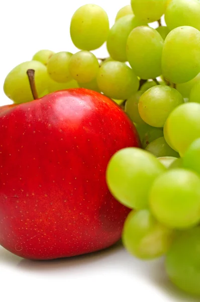 Červené jablko a zelené hrozny — Stock fotografie