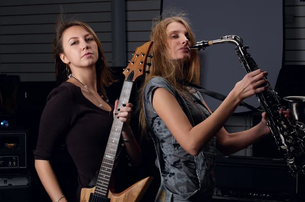 Two young female play on guitar and saxophone — Stock Photo, Image