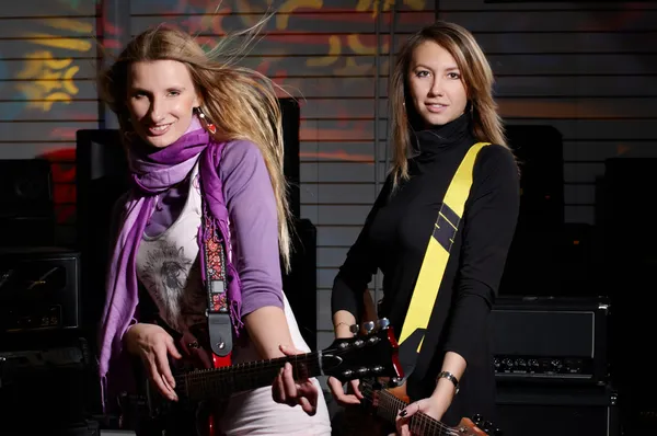Two young females sign the song and play on saxo — Stock Photo, Image