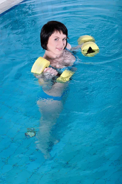 A linda garota a morena nada na piscina — Fotografia de Stock