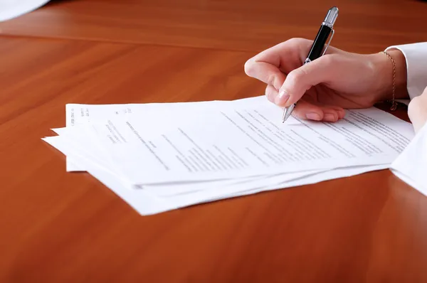 Person's hand signing document Royalty Free Stock Images