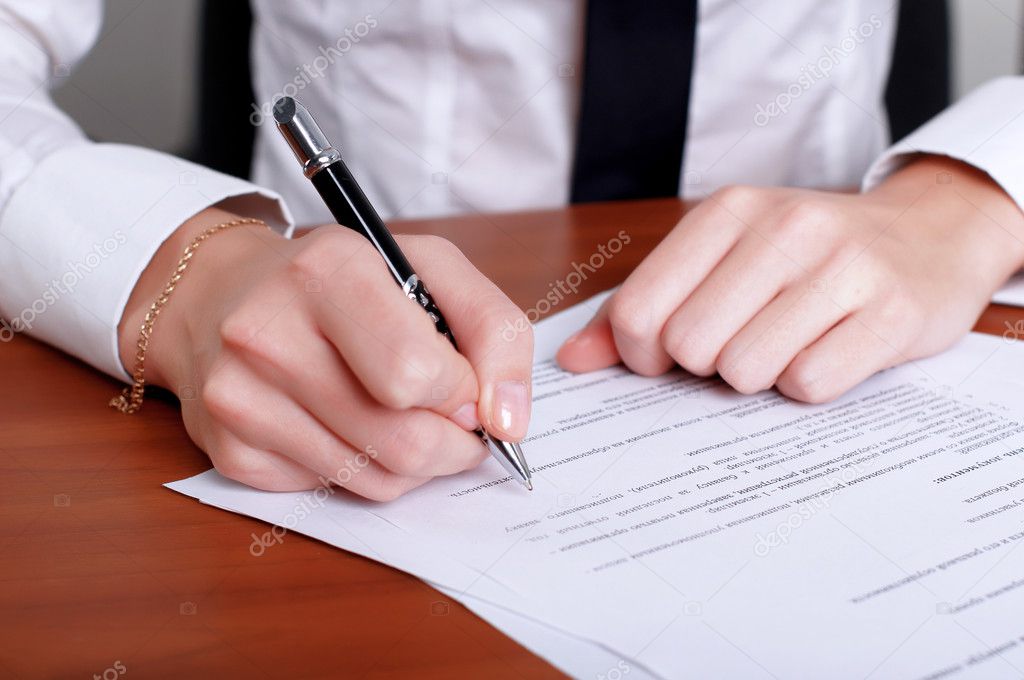 Person's hand signing document