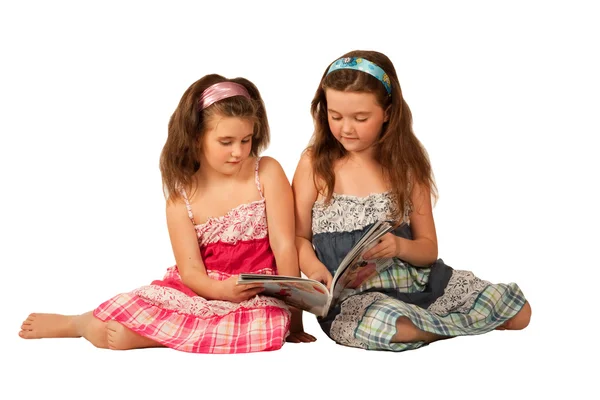 Twee mooie meisjes lezen van een tijdschrift Rechtenvrije Stockafbeeldingen