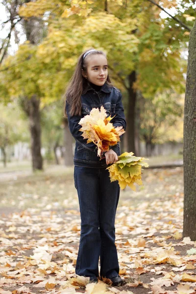 Mädchen und gelbe Blätter im Herbst — Stockfoto