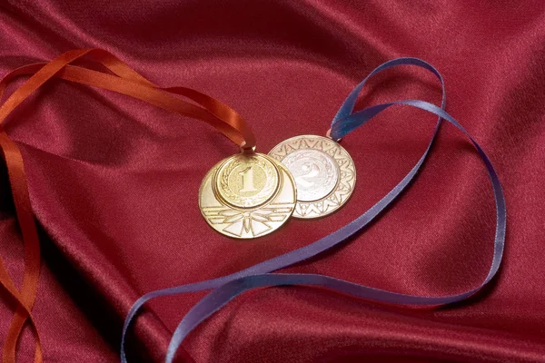 Золоті та срібні медалі на червоному — стокове фото