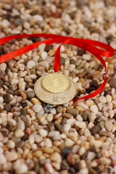 Golden medal on the pebble — Stock Photo, Image