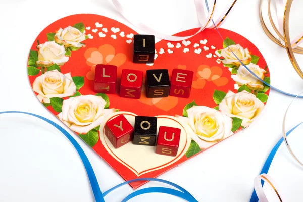Words cubes over heart and ribbons — Stock Photo, Image