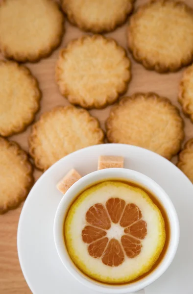 Xícara de chá preto com limão e biscoitos — Fotografia de Stock