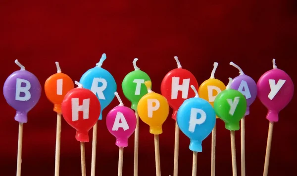 Velas de aniversário felizes em um bolo — Fotografia de Stock