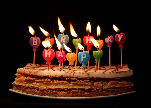 Velas de feliz cumpleaños en un pastel — Foto de Stock