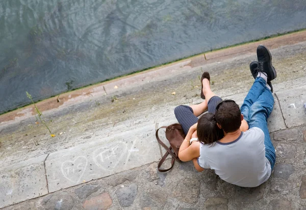 Milující pár sedící na nábřeží Seiny v Paříži, Francie — Stock fotografie