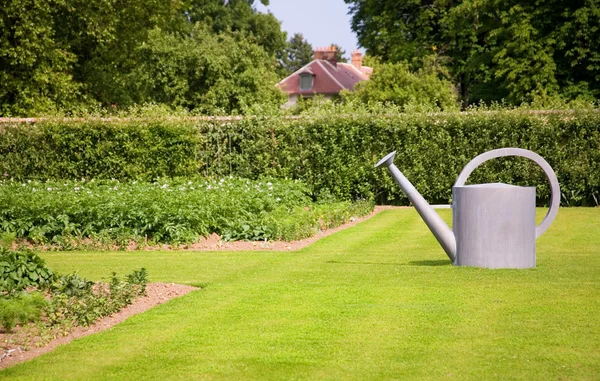 Garden decoration. Big watering can on the lawn — Stock Photo, Image