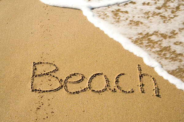 Word Beach written on the sand