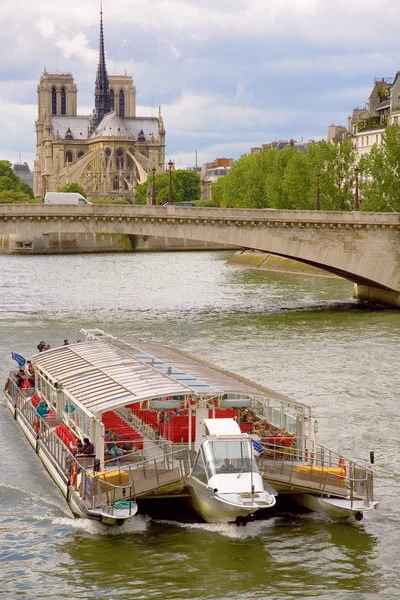 Kilátás az idegenforgalmi csónakot a Szajna és a notre-dame de paris, a háttérben. Paris, Franciaország — Stock Fotó