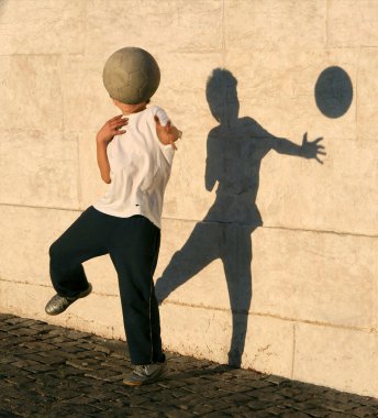 Boy playing catch with his shadow clipart