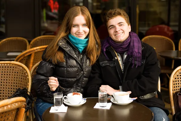 Casal feliz em um café de rua parisiense — Fotografia de Stock