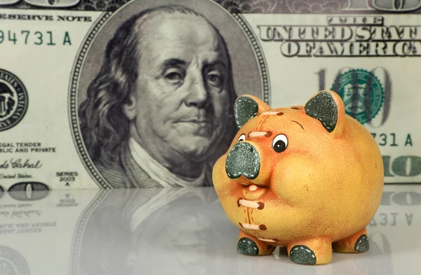 Sparschwein vor großem Dollar-Hintergrund — Stockfoto