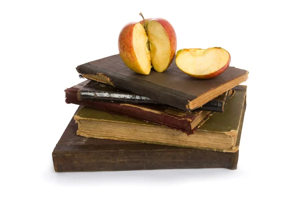Яблоко на куче старых книг — стоковое фото