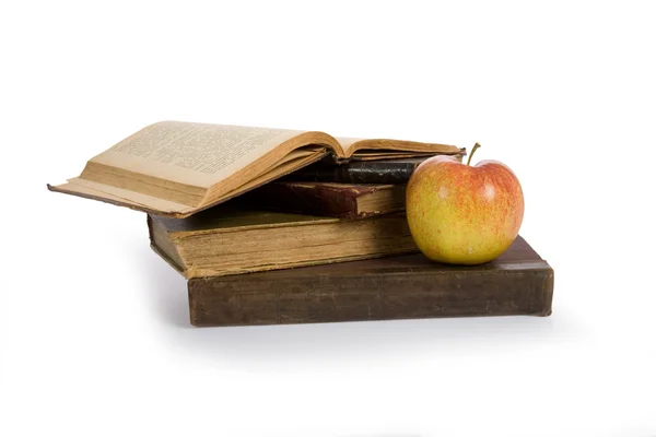 Apple on pile of old books — Stock Photo, Image