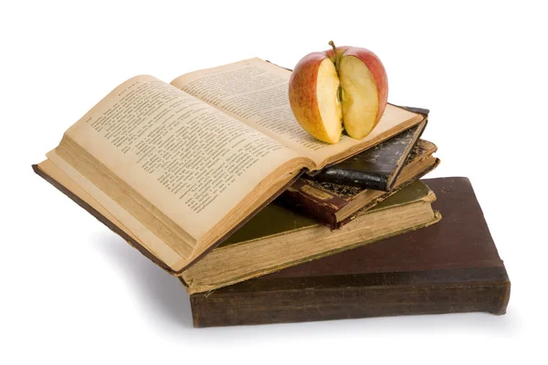 Apple on pile of old books — Stock Photo, Image