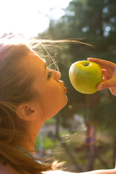 Girl with apple on sunset — Stock Photo, Image