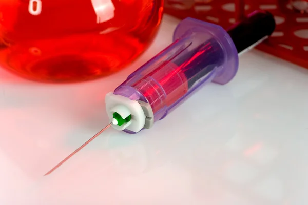 Close up of syringe with test tube — Stock Photo, Image