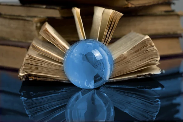 Стеклянный глобус и старая книга — стоковое фото