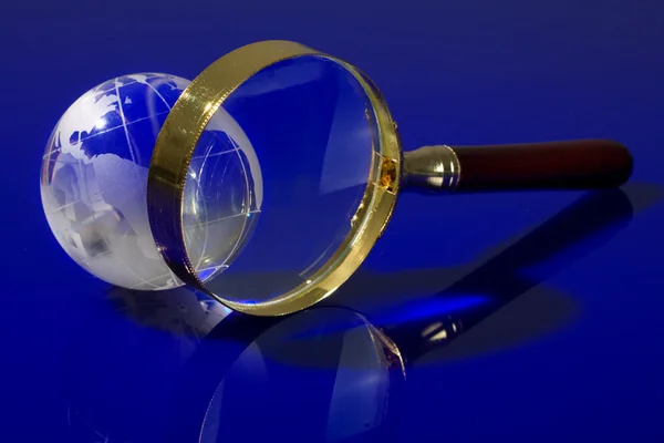 Glass globe with a magnifying glass — Stock Photo, Image