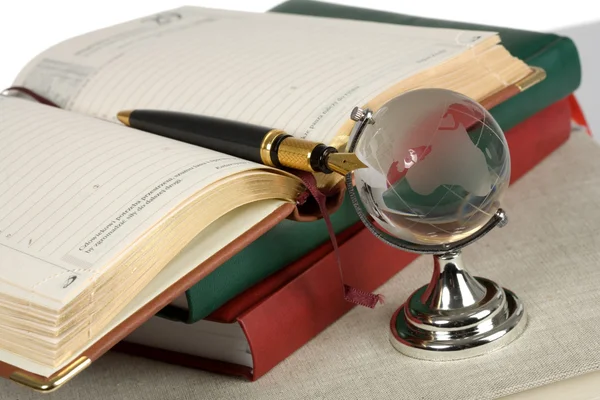 Livro, caneta e globo de vidro — Fotografia de Stock