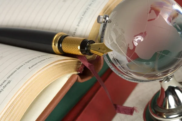 Boek, pen en glazen bol — Stockfoto