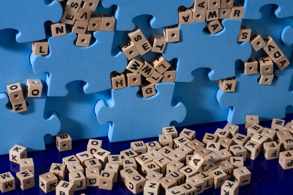 Puzzle azul con letra de madera — Foto de Stock