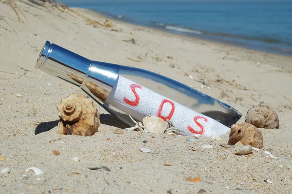 Mensagem em uma garrafa com sinal SOS — Fotografia de Stock