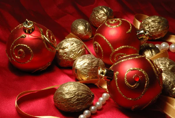 Красные рождественские шары и золотые орехи — стоковое фото