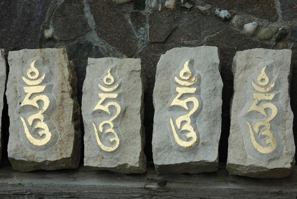 Cuatro piedras con sílaba tibetana sagrada — Foto de Stock