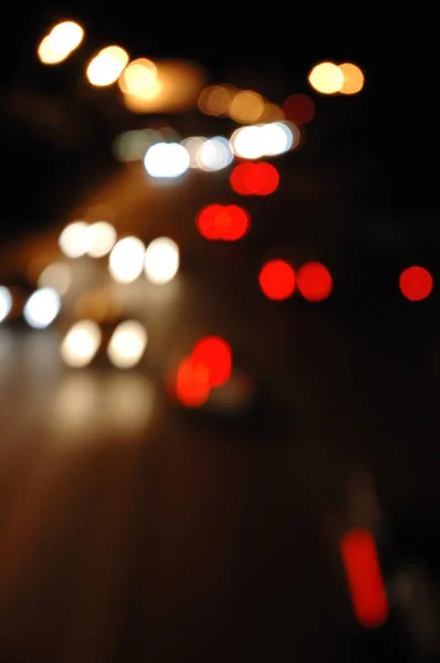 การจราจรบนถนนในเวลากลางคืน นอกโฟกัส — ภาพถ่ายสต็อก