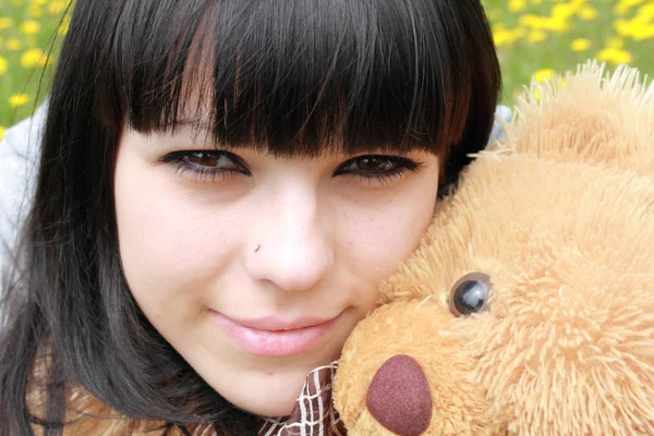 Brunette with plush teddy bear on herb