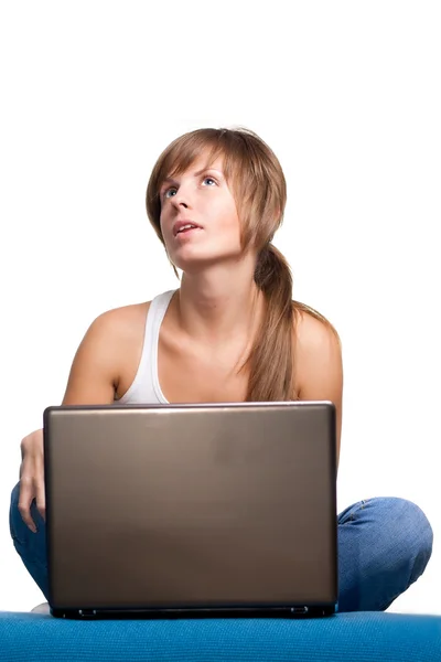 Chica joven pensando con portátil — Foto de Stock