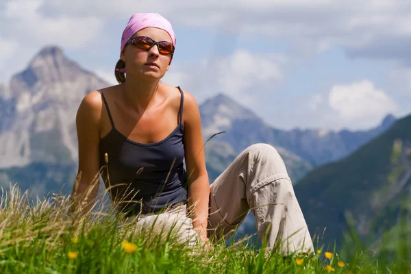Jonge vrouw zitten op een heuvel — Stockfoto