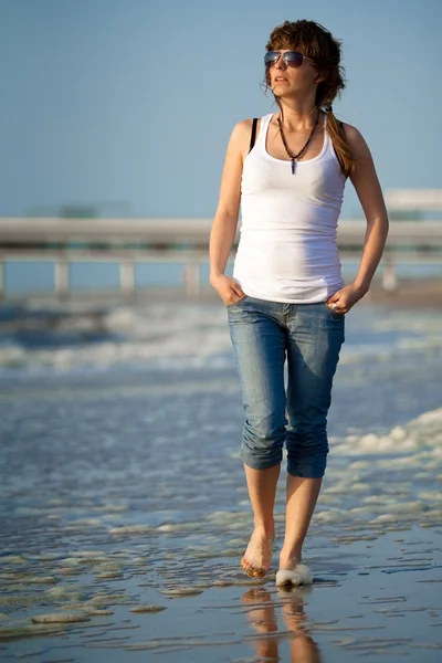 Chica joven caminando en una playa —  Fotos de Stock