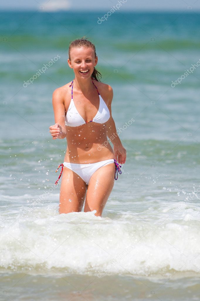 Happy young woman standing in sea