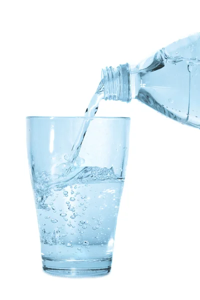 Agua que vierte de la botella en vidrio —  Fotos de Stock
