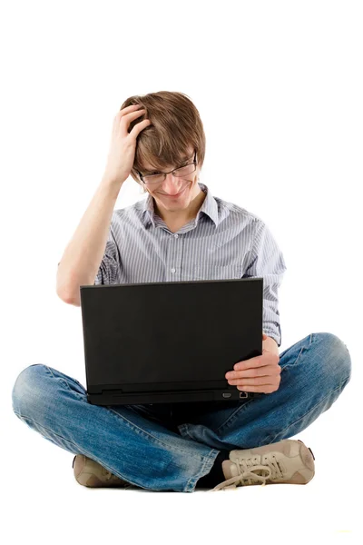 Junger Mann denkt mit Laptop — Stockfoto
