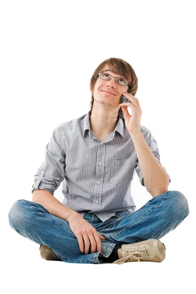 Junger Mann sieht mit Handy verträumt aus lizenzfreie Stockbilder