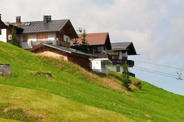 Alpine chalets on hill. Summer time clipart