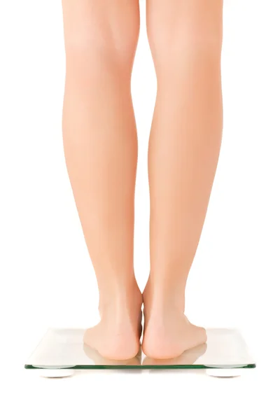 Женские ноги на весах — стоковое фото