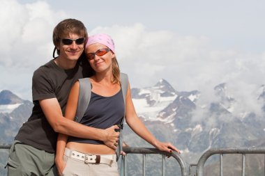 Young couple high in the mountains clipart