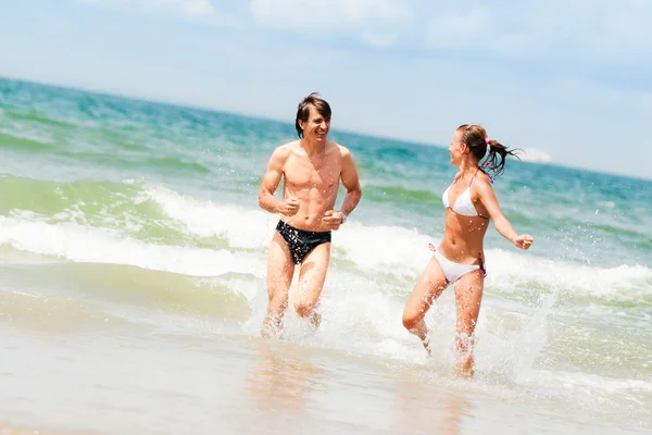 Νεαρό ζευγάρι χαρούμενος στην παραλία — Φωτογραφία Αρχείου