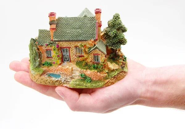 Een klein huis in handen — Stockfoto